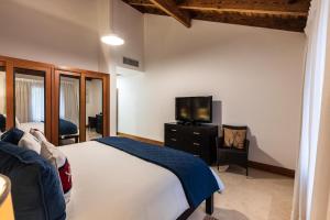 1 dormitorio con 1 cama y TV de pantalla plana en Marina Front Villa at Puerto Bahía -Breakfast incl en Santa Bárbara de Samaná