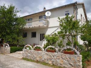 a house with a stone wall in front of it at Apartments Seline - Paklenica Riviera 27380 in Seline
