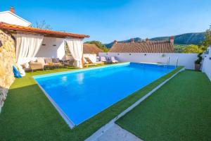 a swimming pool in a villa with green grass at Holiday home in Tribalj 5643 in Tribalj