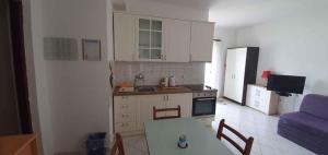 a kitchen with white cabinets and a table and a blue couch at Apartments in Vinisce 7372 in Vinišće