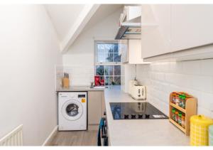 a kitchen with a washer and dryer on a counter at Fresh and Relaxing 1 BD Flat in Manchester
