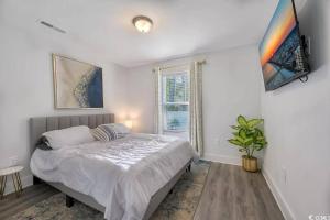Brand New Home 3 Bed 25 bath, 4min walk to beach في ميرتل بيتش: غرفة نوم بيضاء بها سرير ونافذة