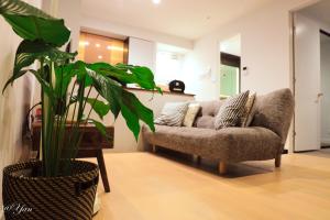 a living room with a couch and a plant at New Year eve’s Fireworks & BayView Apt in CBD in Melbourne