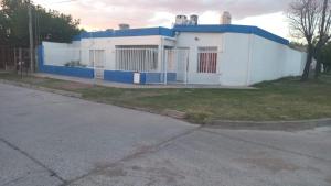 ein weißes und blaues Haus mit einem Zaun in der Unterkunft Casa LA ARGENTINA in San Luis