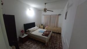 ein kleines Schlafzimmer mit einem Bett und einem Deckenventilator in der Unterkunft Casa LA ARGENTINA in San Luis
