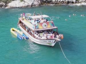 Una barca in acqua con delle persone sopra. di Pousada Arraial do Cabo - Praia dos Anjos ad Arraial do Cabo