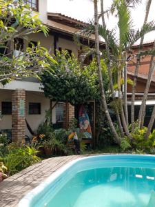 a swimming pool in front of a house at Tucano House in Florianópolis