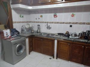 a kitchen with a sink and a washing machine at Calm And Peaceful in Marrakesh