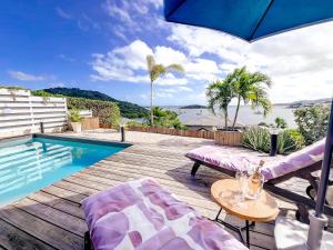 a swimming pool with two chairs and an umbrella at Little Paradise 1, 3 bedrooms, private pool, Cul de Sac Bay view in Cul de Sac