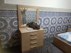 a bedroom with a dresser with a mirror and a bed at Calm And Peaceful in Marrakesh