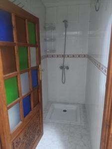 a bathroom with a shower and a toilet with a door at Calm And Peaceful in Marrakesh
