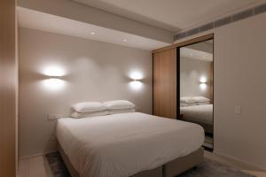 a bedroom with two beds and a mirror at City Living at it's Finest on Clarence in Sydney