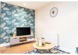 a living room with a tv and a table at 2 Bedroom Apartment in Perfect Location in Enfield Lock
