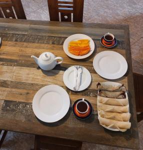 a wooden table with plates of food on it at Mystique Hideout in Kandy