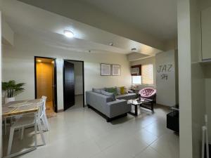 - un salon avec un canapé et une table dans l'établissement JAZ Stays Bacolod, à Bacolod