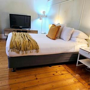 a bedroom with a large bed with a television on it at Cobb & CoHouse -Luxury Large Home BendigoCBD in Bendigo
