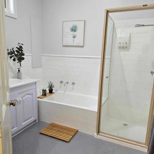 a bathroom with a shower and a bath tub at Cobb & CoHouse -Luxury Large Home BendigoCBD in Bendigo