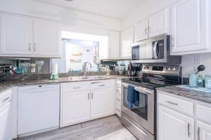 een keuken met witte kasten en roestvrijstalen apparatuur bij Cozy Beach Oasis 2 Bdrm Condo in Destin in Destin