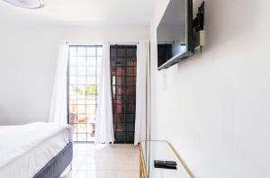 a bedroom with a bed and a tv on a wall at Residencial García apt 5 in La Romana