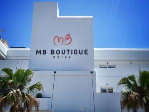 a sign on the side of a building with palm trees at MB Boutique Hotel - Adults Recommended in Nerja