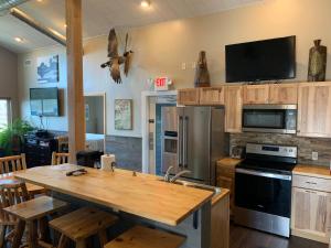 a kitchen with a wooden table and a refrigerator at Luckys Lodge in Lodi