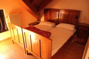 a bedroom with a large bed with a wooden headboard at Apartment in Passo Rolle/Südtirol 23444 in Passo Rolle