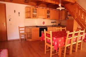 a kitchen with a table and chairs in a room at Apartment in Passo Rolle/Südtirol 23444 in Passo Rolle