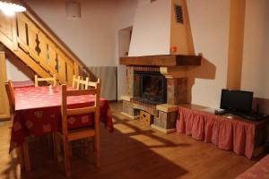 a living room with a table and a fireplace at Apartment in Passo Rolle/Südtirol 23444 in Passo Rolle