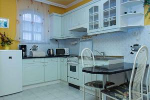 バラトンマーリアフュルドゥーにあるHoliday home in Balatonmariafürdo 19536の白いキッチン(白いキャビネット、シンク付)