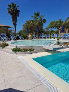 einen Pool mit Stühlen und einem Pool in der Unterkunft Apartments Capo Vaticano/Kalabrien 21016 in Ricadi
