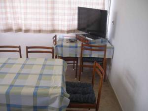 a room with a table with a television and chairs at Apartment in Lopar - Insel Rab 16055 in Lopar
