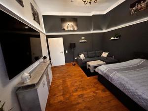 een woonkamer met een bed en een bank bij DZ Appartements - Ferienwohnung mit Klimaanlage, inkl. WLAN, Betten nach Bedarf stellbar in Wittenberge