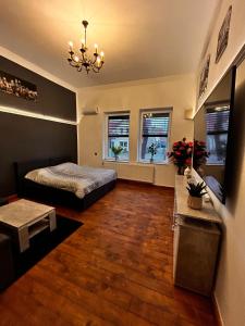 a bedroom with a bed and a table and windows at DZ Appartements - Ferienwohnung mit Klimaanlage, inkl. WLAN, Betten nach Bedarf stellbar in Wittenberge