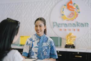 Peranakan House - SHA Plus في فوكيت تاون: امرأة تتحدث إلى امرأة أخرى في غرفة