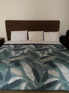a bedroom with a bed with a green and white blanket at Condominio Mansiones Cruz del Mar 002 in Santa Cruz Huatulco