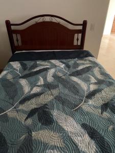 a bed with a green and white quilt on it at Condominio Mansiones Cruz del Mar 002 in Santa Cruz Huatulco +2 photos