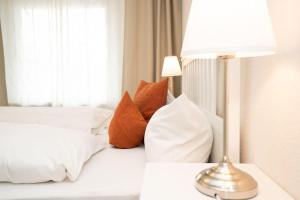 - un lit blanc avec des oreillers et une lampe sur une table dans l'établissement Norderhoog-Whg-30-1-OG-Wohnung-30, à Westerland