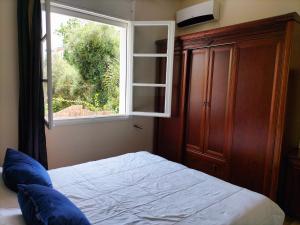 a bedroom with a bed and a window at Villa Pierrette Casablanca in Casablanca