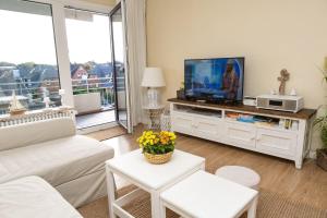 ein Wohnzimmer mit einem TV in einem Entertainment-Center in der Unterkunft Norderhoog 2.OG / O Wohnung 45 in Westerland
