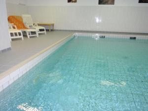 ein großer Pool mit blauem Wasser in einem Zimmer in der Unterkunft Norderhoog 2.OG / O Wohnung 45 in Westerland