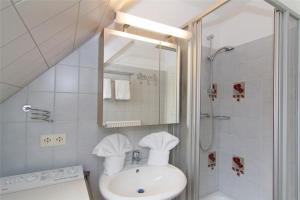 a bathroom with a sink and a shower with a mirror at Haus-Seemoewe in Archsum