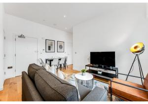 un soggiorno con divano e TV di Stylish Flat in Centre Hassle Free Peaceful a Maidenhead