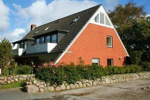 a large red brick house with a black roof at Haus-Seemoewe in Archsum