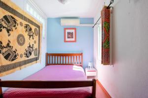 ein kleines Schlafzimmer mit einem Bett mit einer lila Decke in der Unterkunft AroeiraMIR Villa with private pool and beach in Arieiro + 33 Fotos