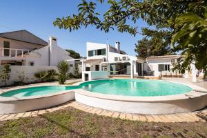 uma piscina em frente a uma casa em AroeiraMIR Villa with private pool and beach em Arieiro