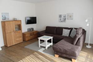 ein Wohnzimmer mit einem Sofa und einem Tisch in der Unterkunft Ferienwohnung ADL/1 1 in Sankt Peter-Ording