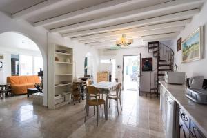 uma cozinha e sala de estar com mesa e cadeiras em AroeiraMIR Villa with private pool and beach em Arieiro