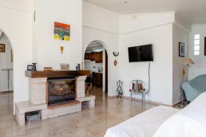 uma sala de estar com lareira e televisão em AroeiraMIR Villa with private pool and beach em Arieiro