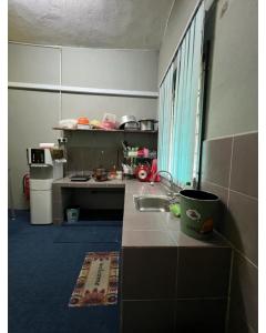 eine kleine Küche mit einer Spüle und einer Theke in der Unterkunft HOMESTAY Kg TOKKU KOTA JEMBAL in Kota Bharu