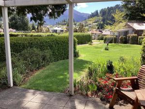 a view of a garden with a bench and a lawn at Hanmer Garden Suites in Hanmer Springs